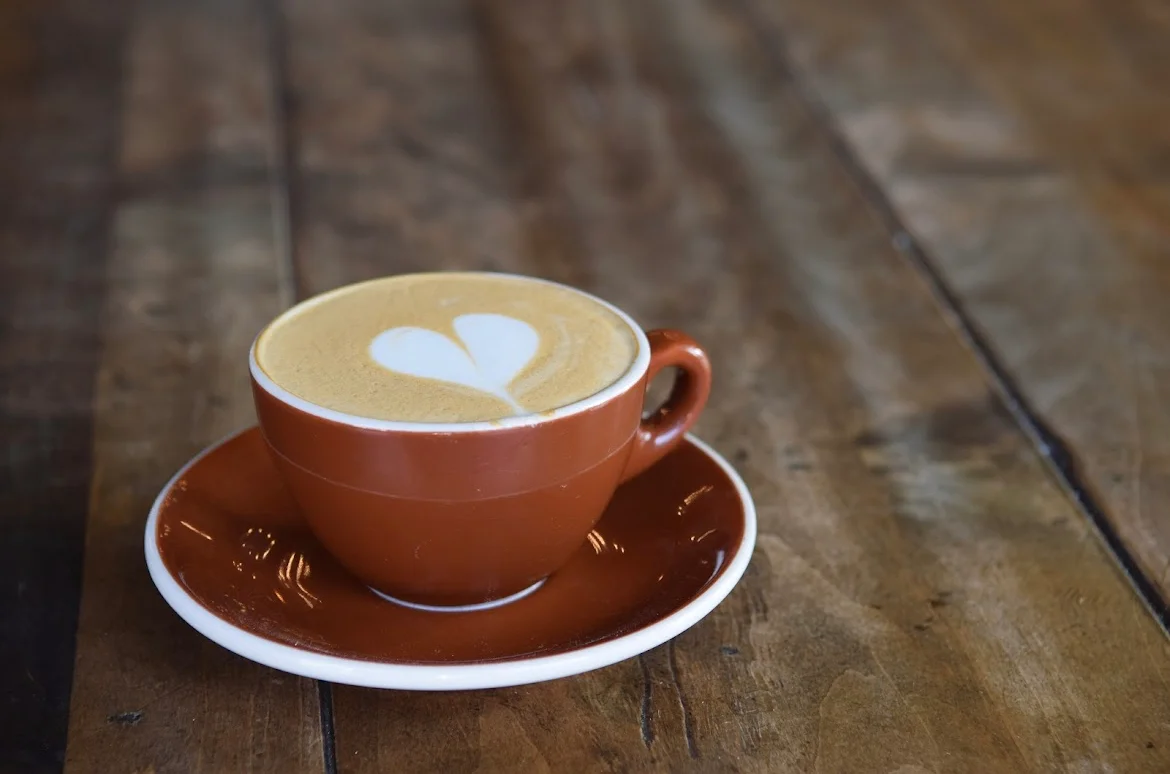 Cappuccino with heart latte art in a cozy café