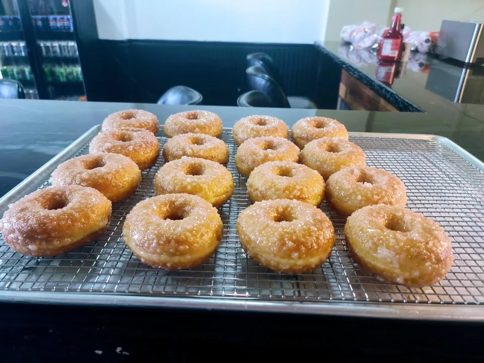 Freshly made glazed donuts on a cooling rack