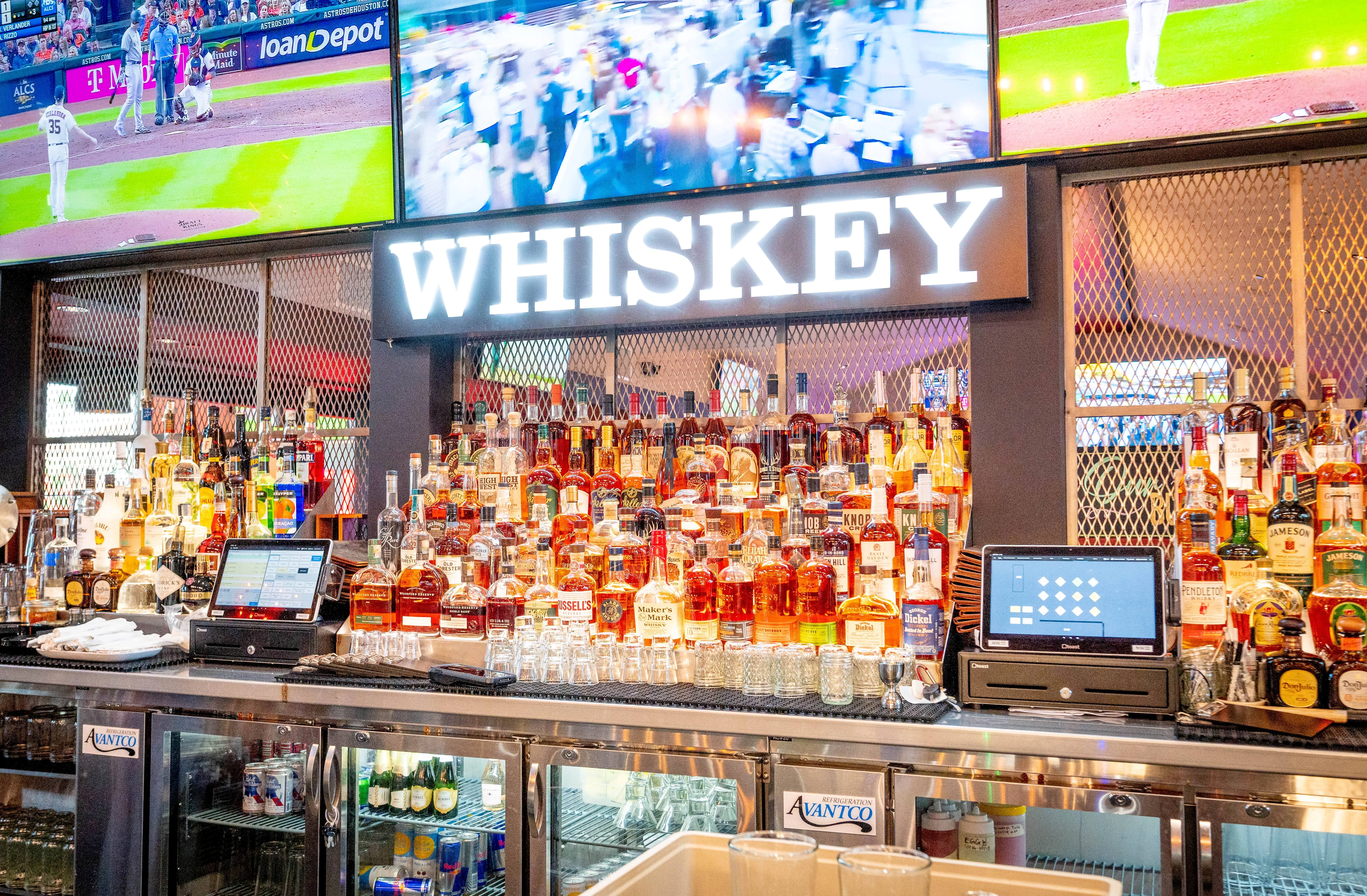 Image of a bar with a lot of whiskey bottles displayed