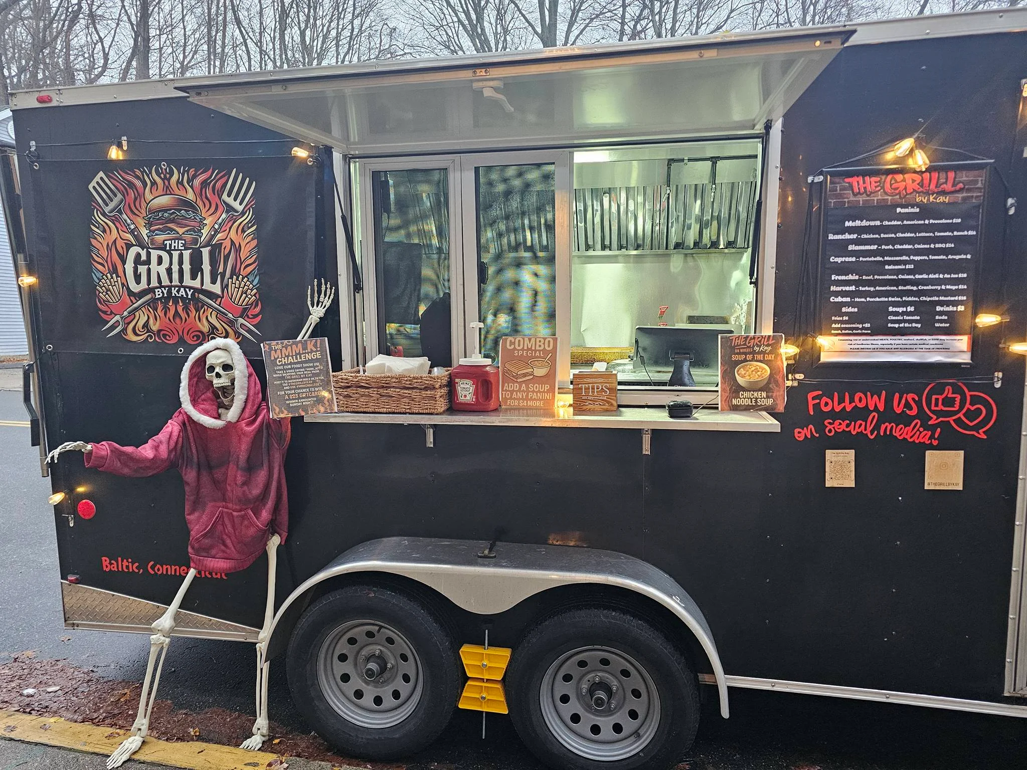 Food truck exterior with skeleton mascot and menu in Baltic, Connecticut