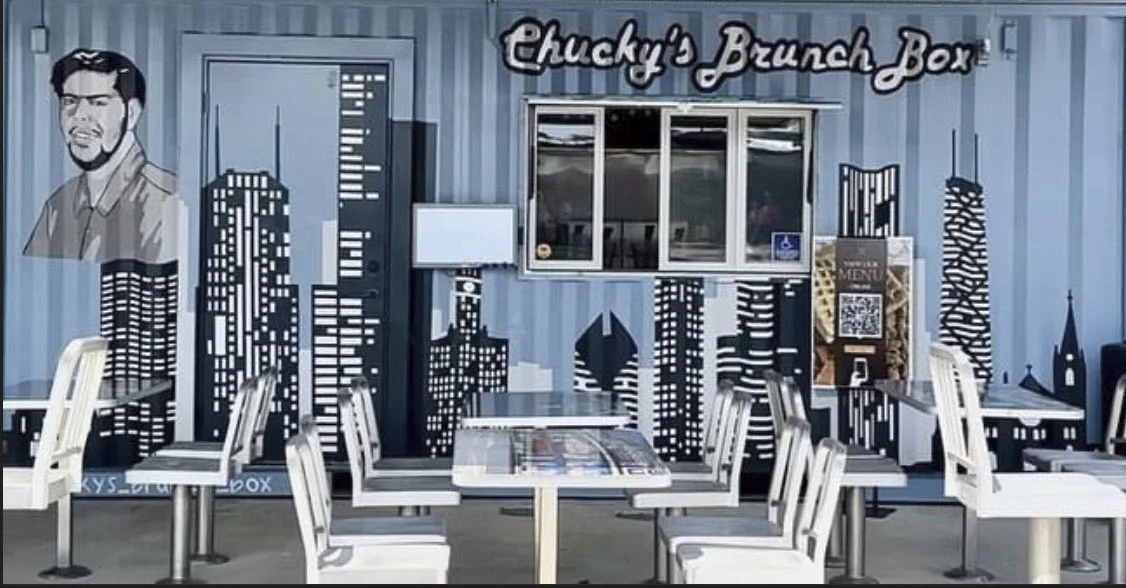 Colorful restaurant exterior with urban mural and outdoor seating