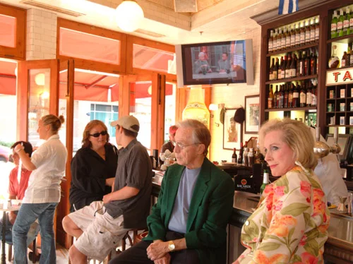 Cozy restaurant interior with patrons enjoying drinks and conversation