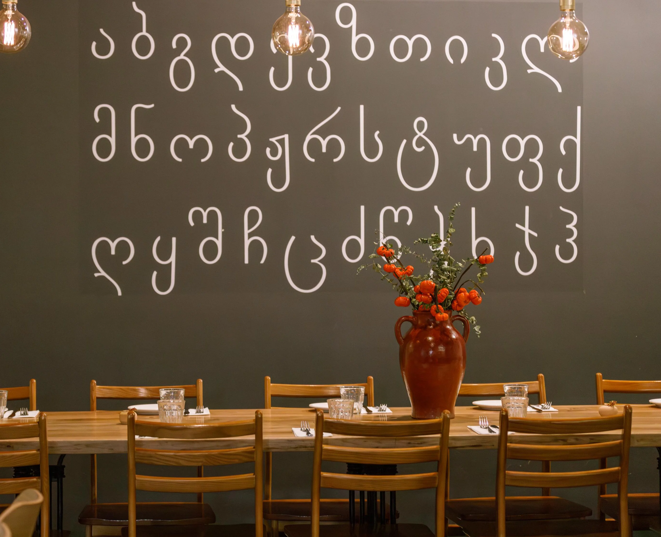 Cozy restaurant interior with artistic wall decor and wooden tables