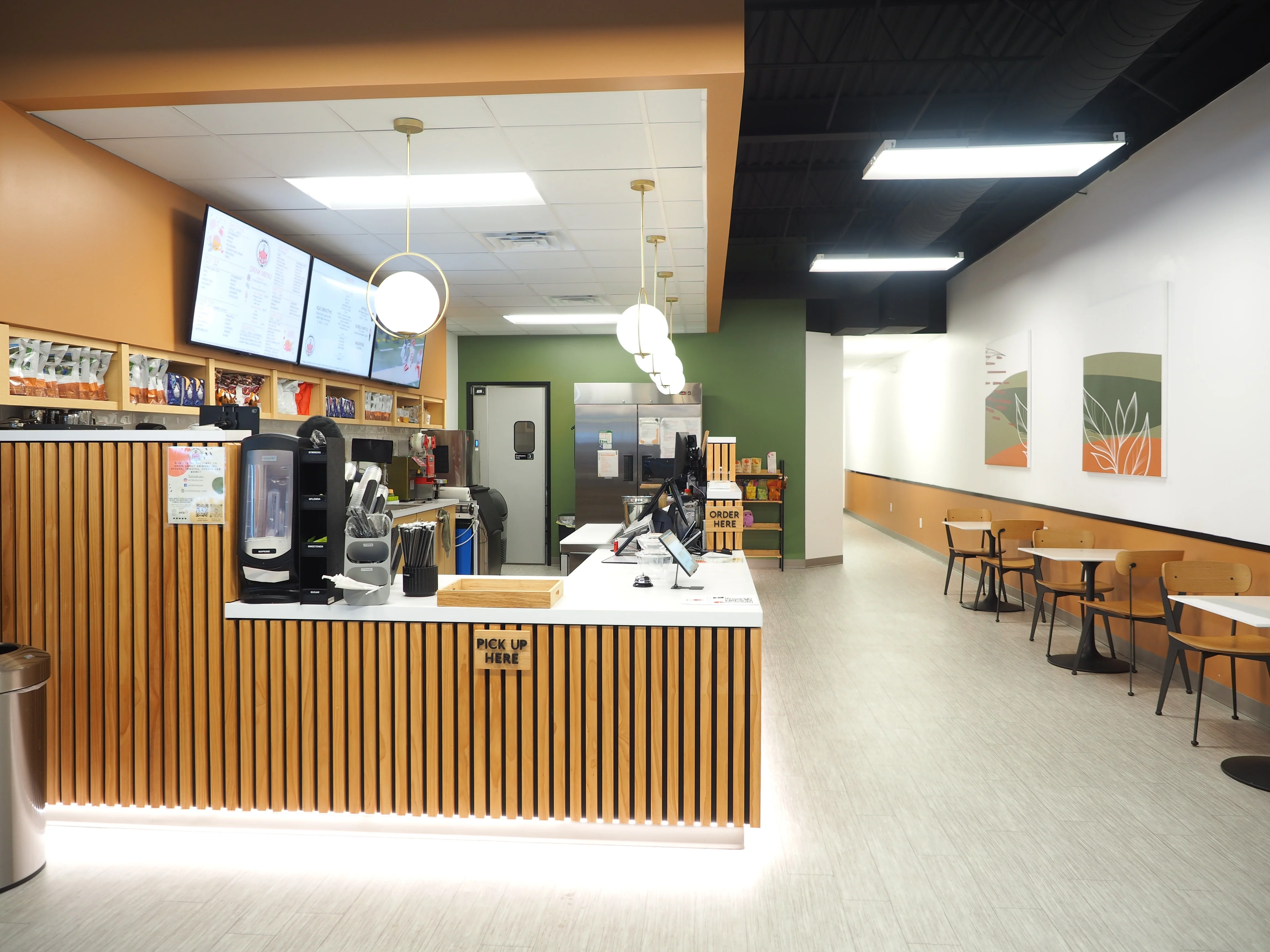 Modern restaurant interior with a sleek counter and digital menu displays