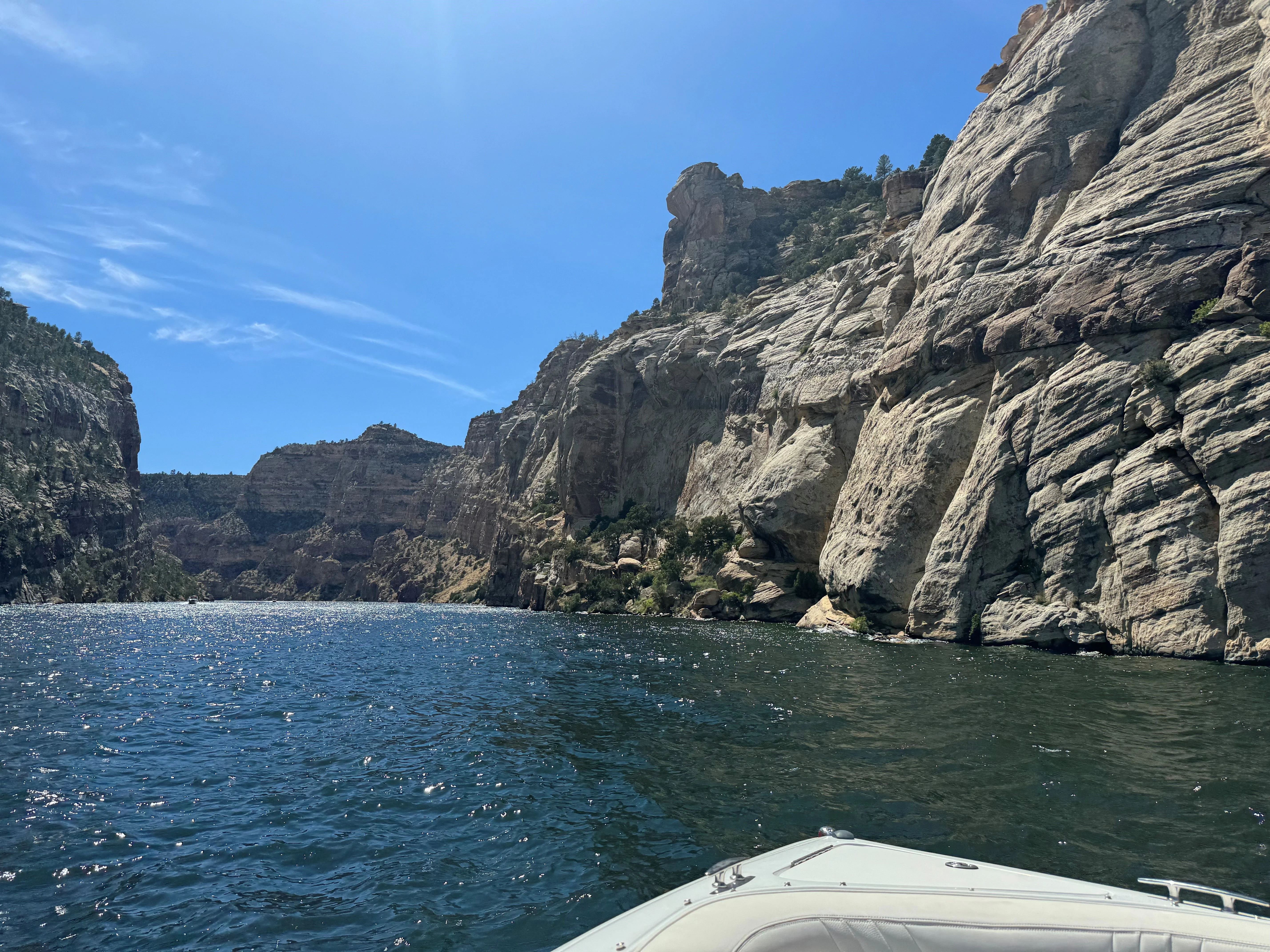Scenic view of rocky cliffs and blue water under a clear sky