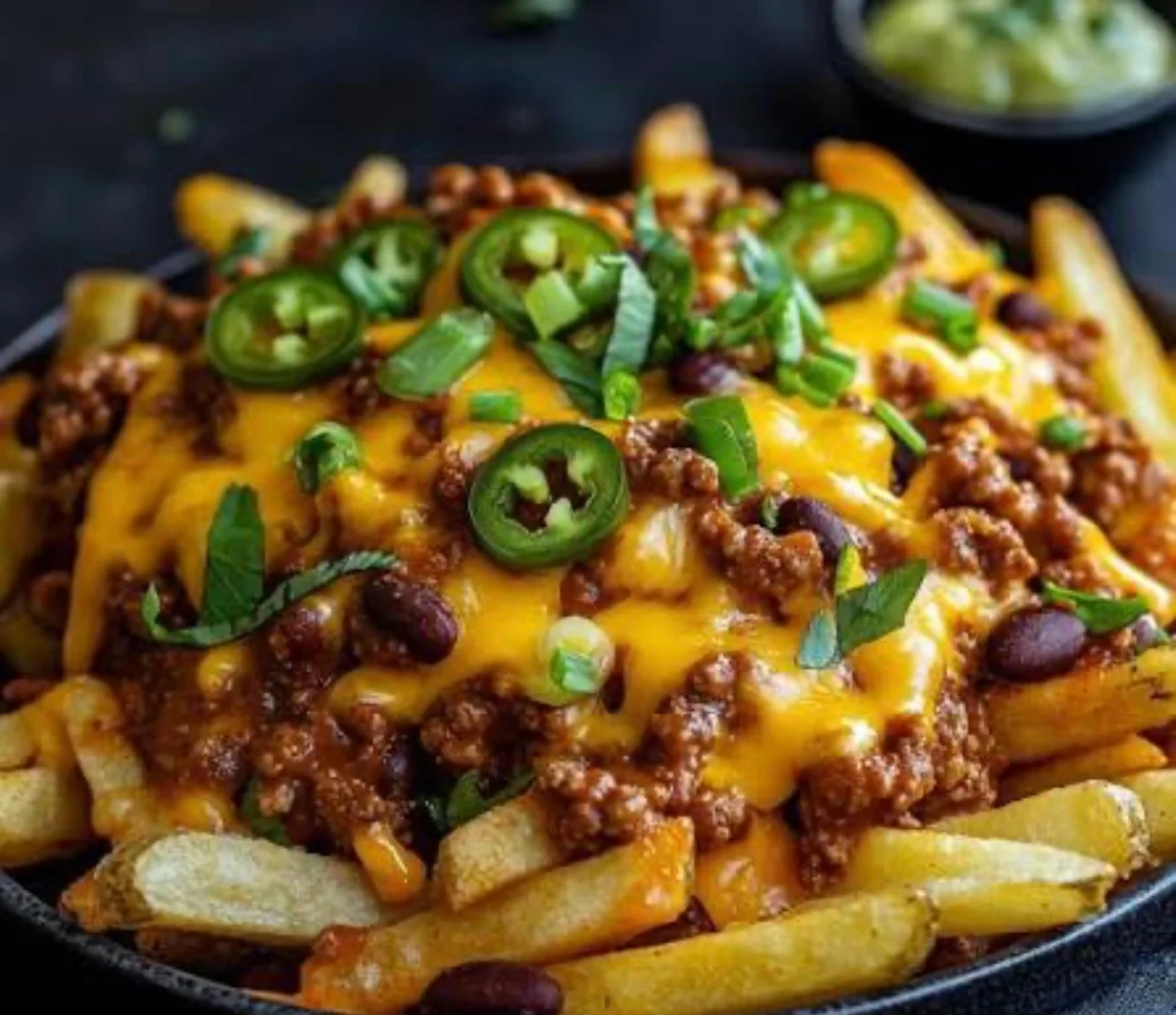 Loaded fries topped with chili, cheese, jalapeños, and green onions.