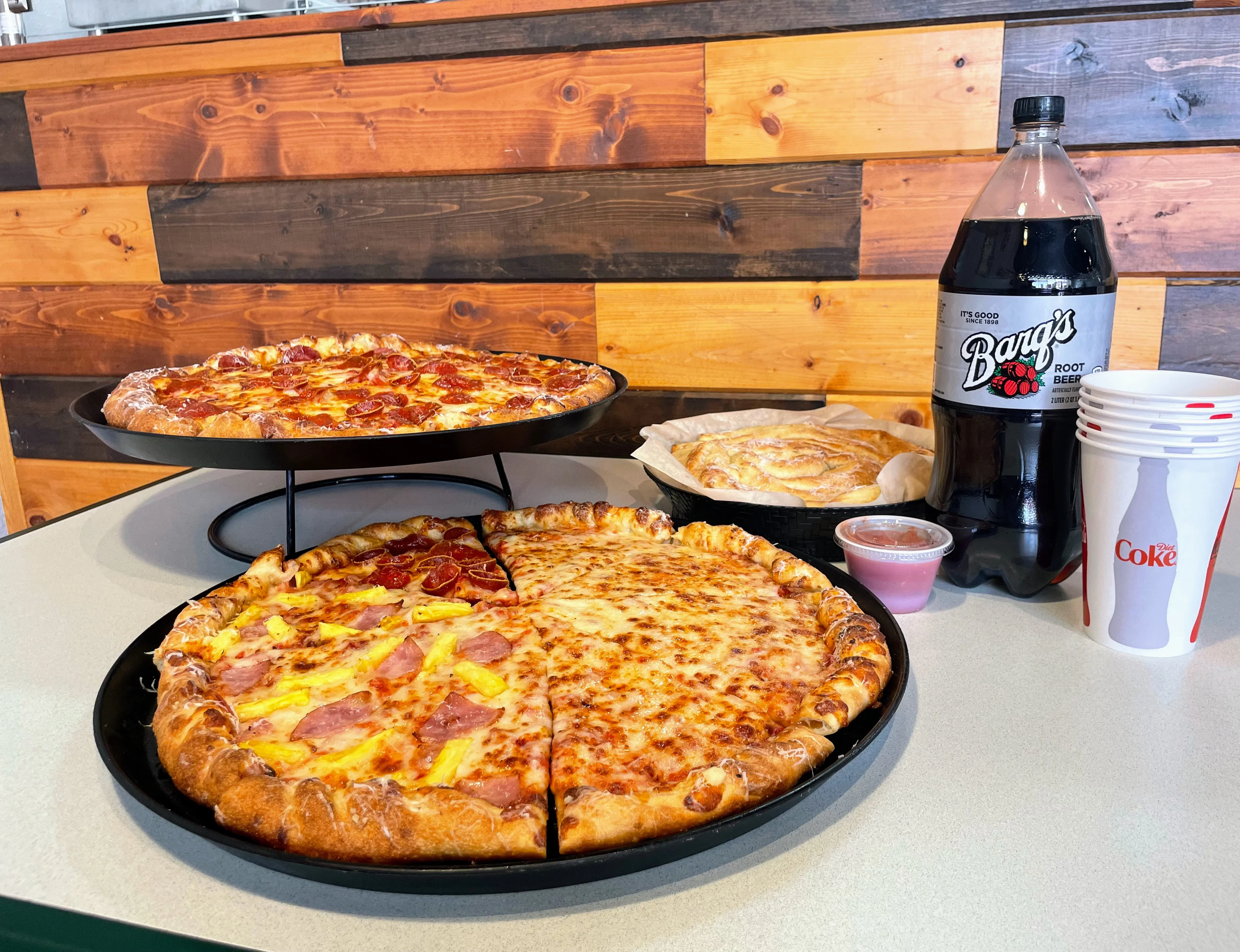 Two pizzas with pepperoni and Hawaiian style in a casual dining setting