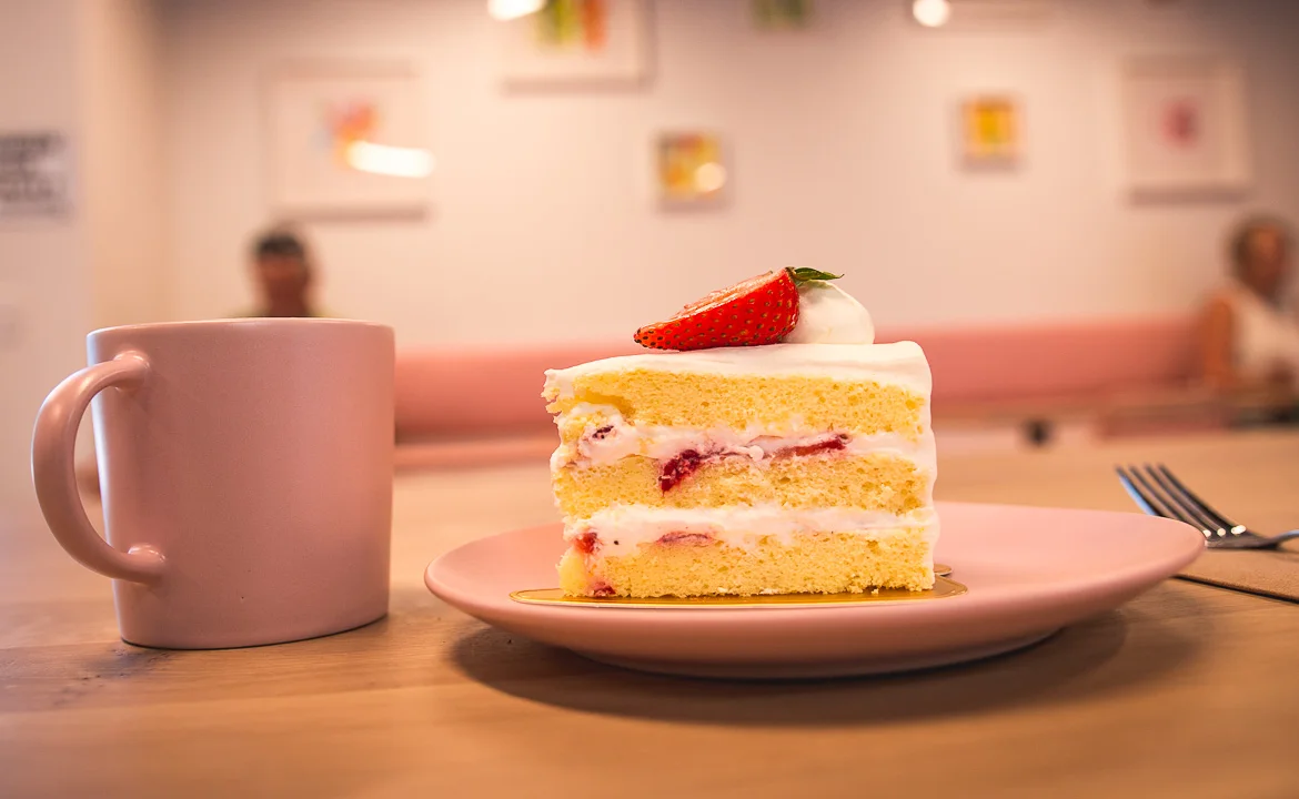 Slice of strawberry shortcake on a pink plate