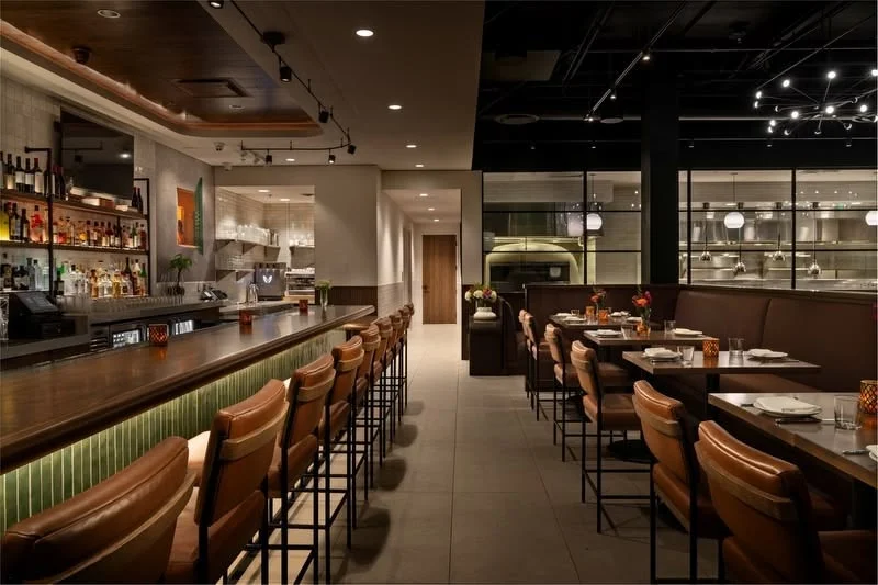 Modern restaurant interior with bar seating and open kitchen