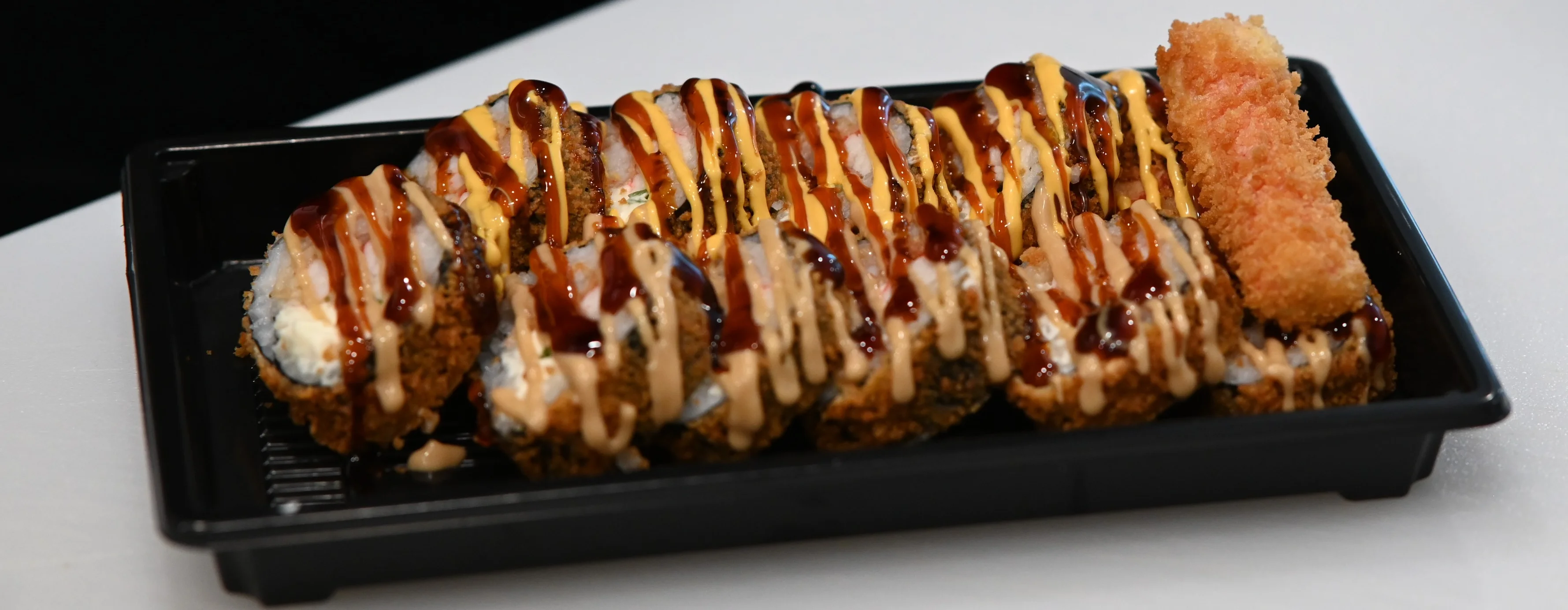 Japanese sushi rolls drizzled with sauces