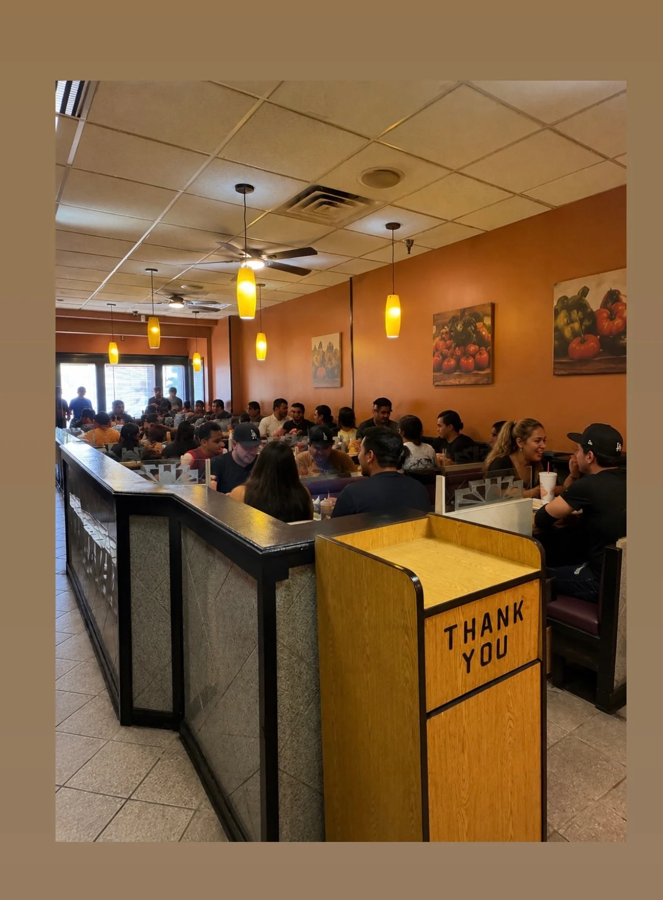 Busy restaurant interior with diners enjoying meals and warm lighting