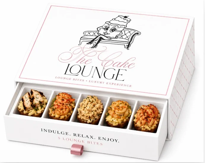 A beautifully designed box of lounge bite desserts featuring five distinct flavors. Each dessert is showcased in its own compartment, with a stylish logo on the lid.