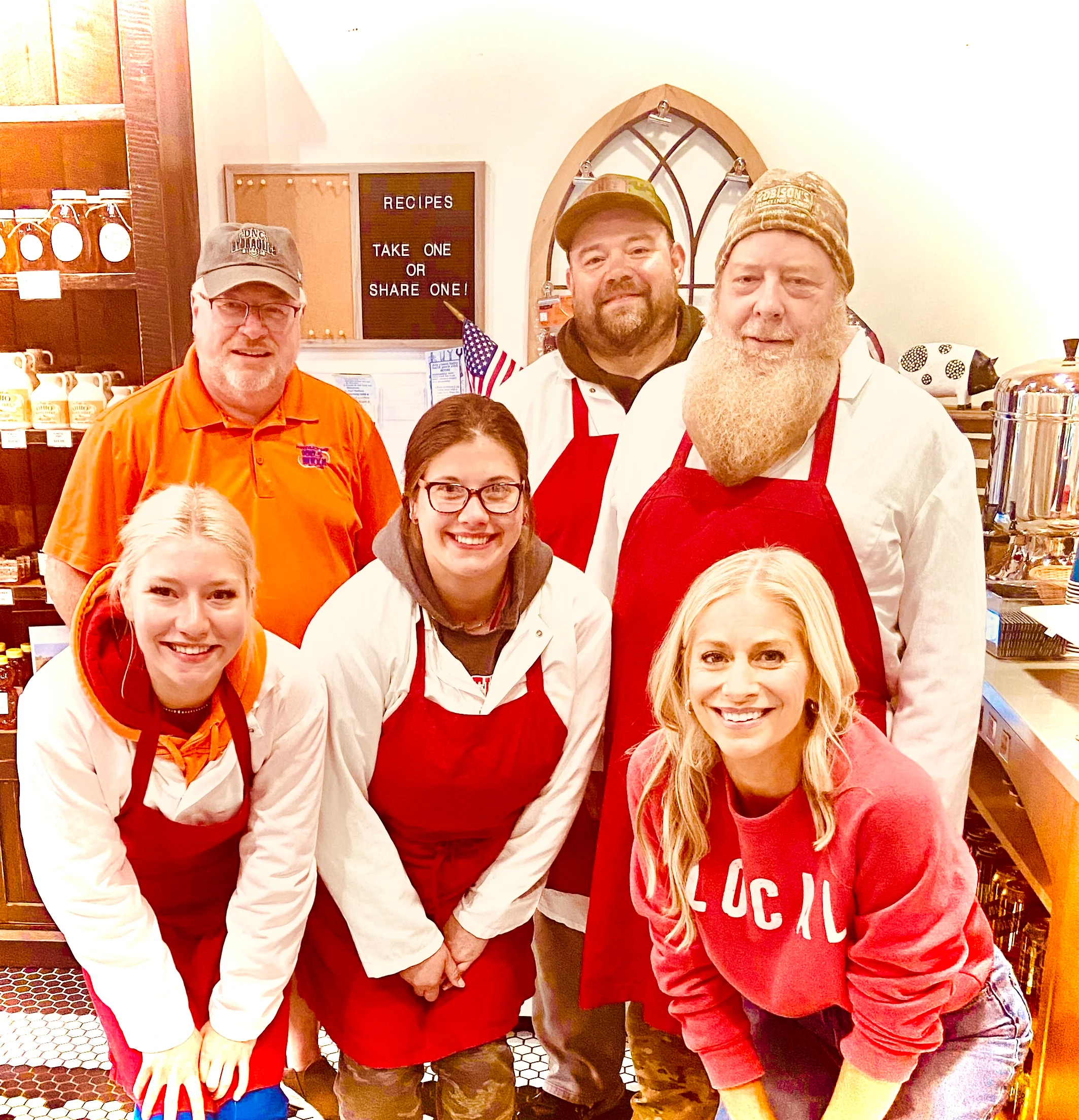 Friendly restaurant staff posing together in aprons