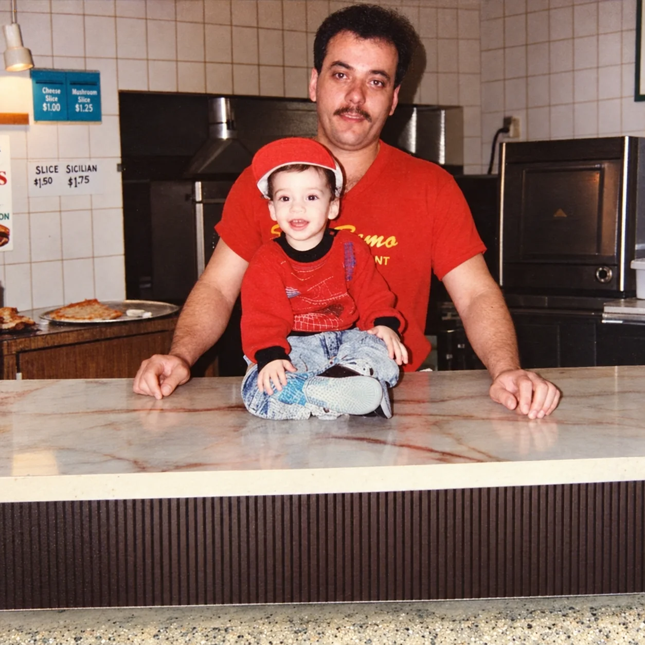 San Remo founder with his young son on the pizzeria counter, circa 1991