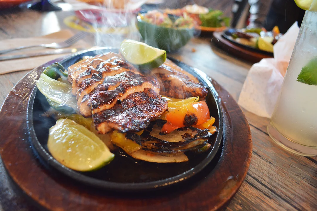 Sizzling fajitas served on a hot skillet