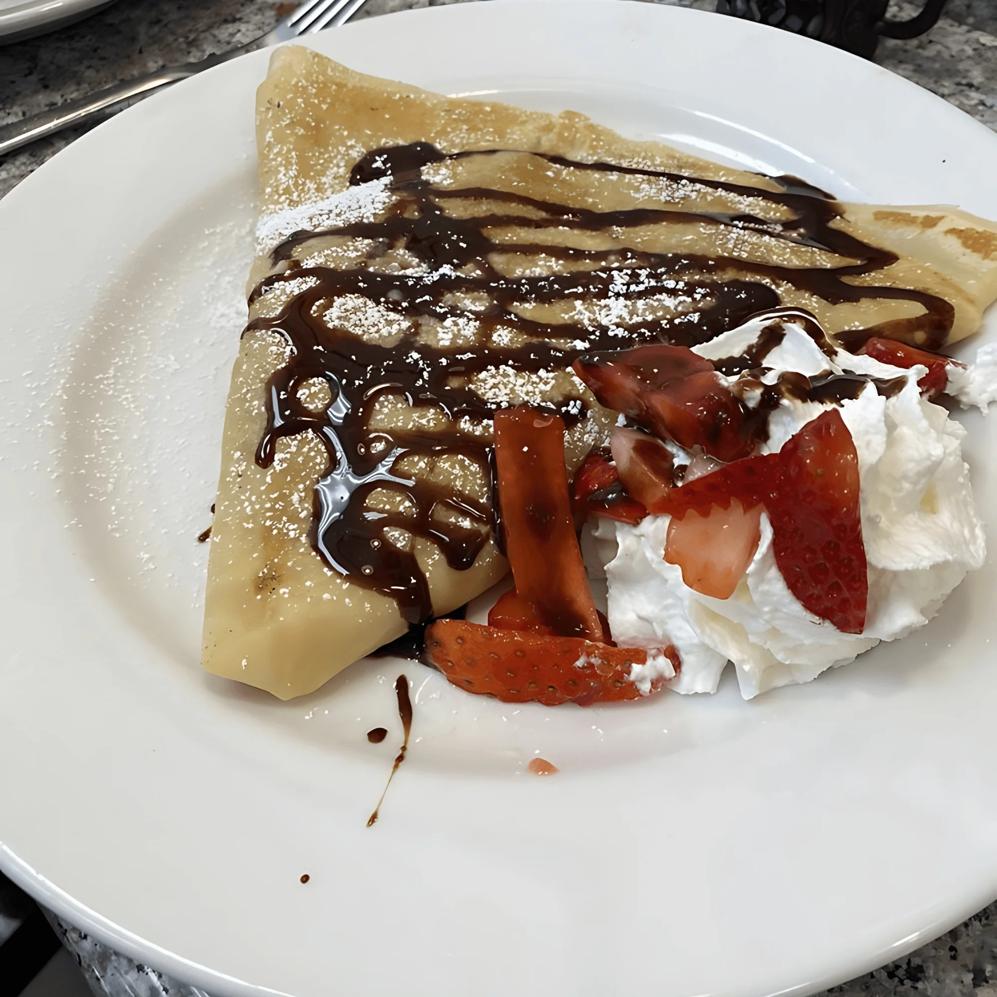 Delicious French crêpe with chocolate sauce and strawberries