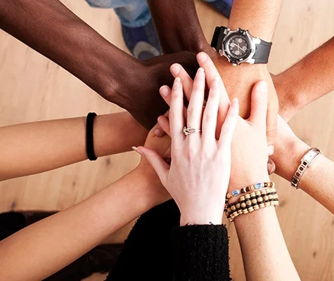 Diverse hands joining together in teamwork