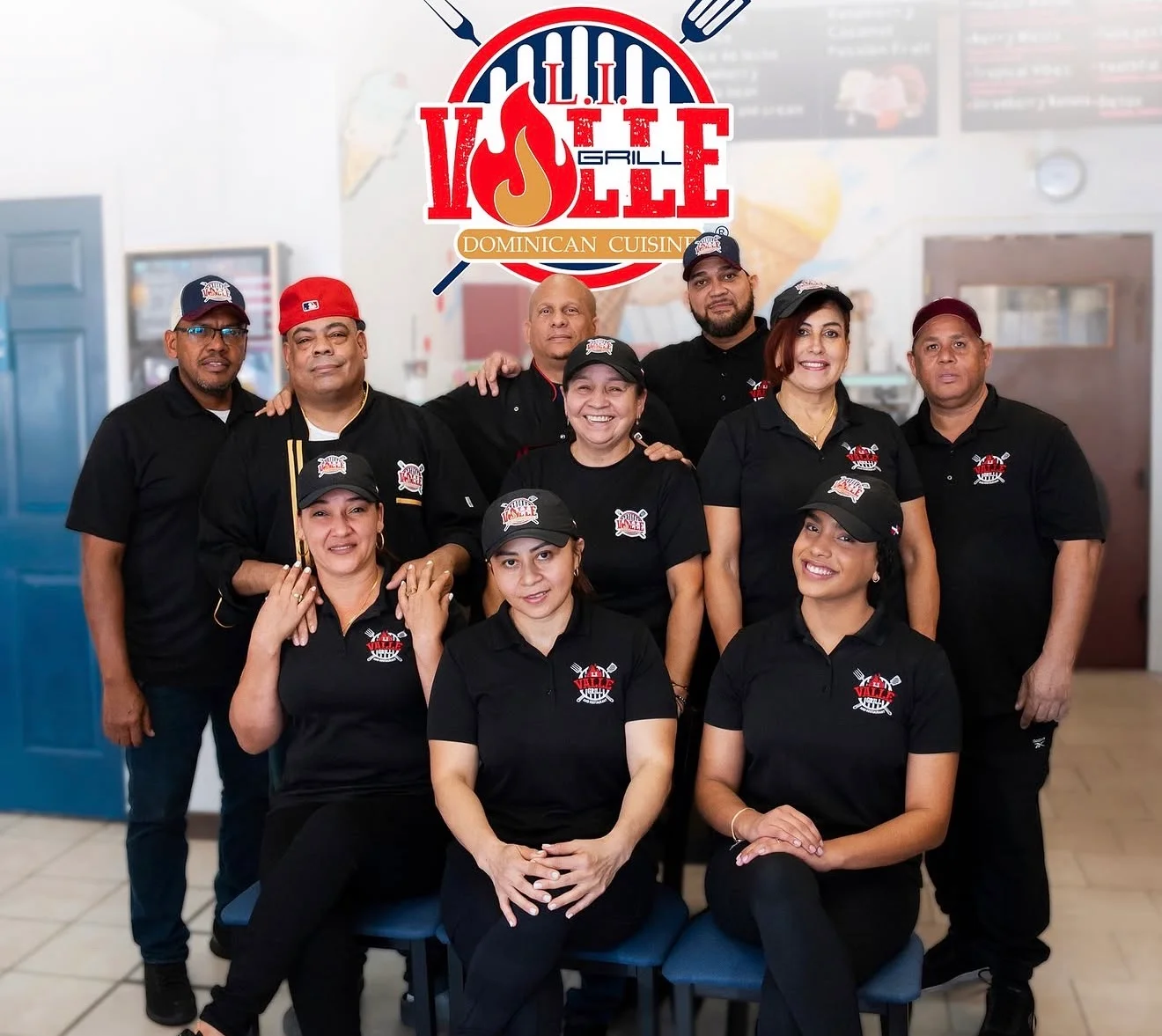 Team of staff at a Dominican restaurant with logo in background