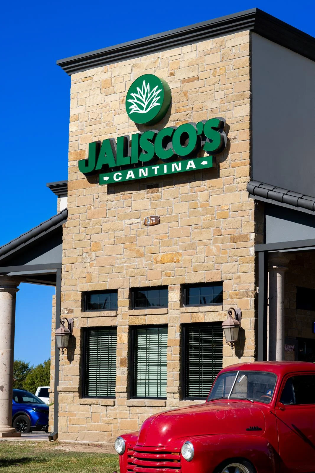 A storefront sign for Jalisco's Cantina featuring 'Authentic Mexican Food' text.