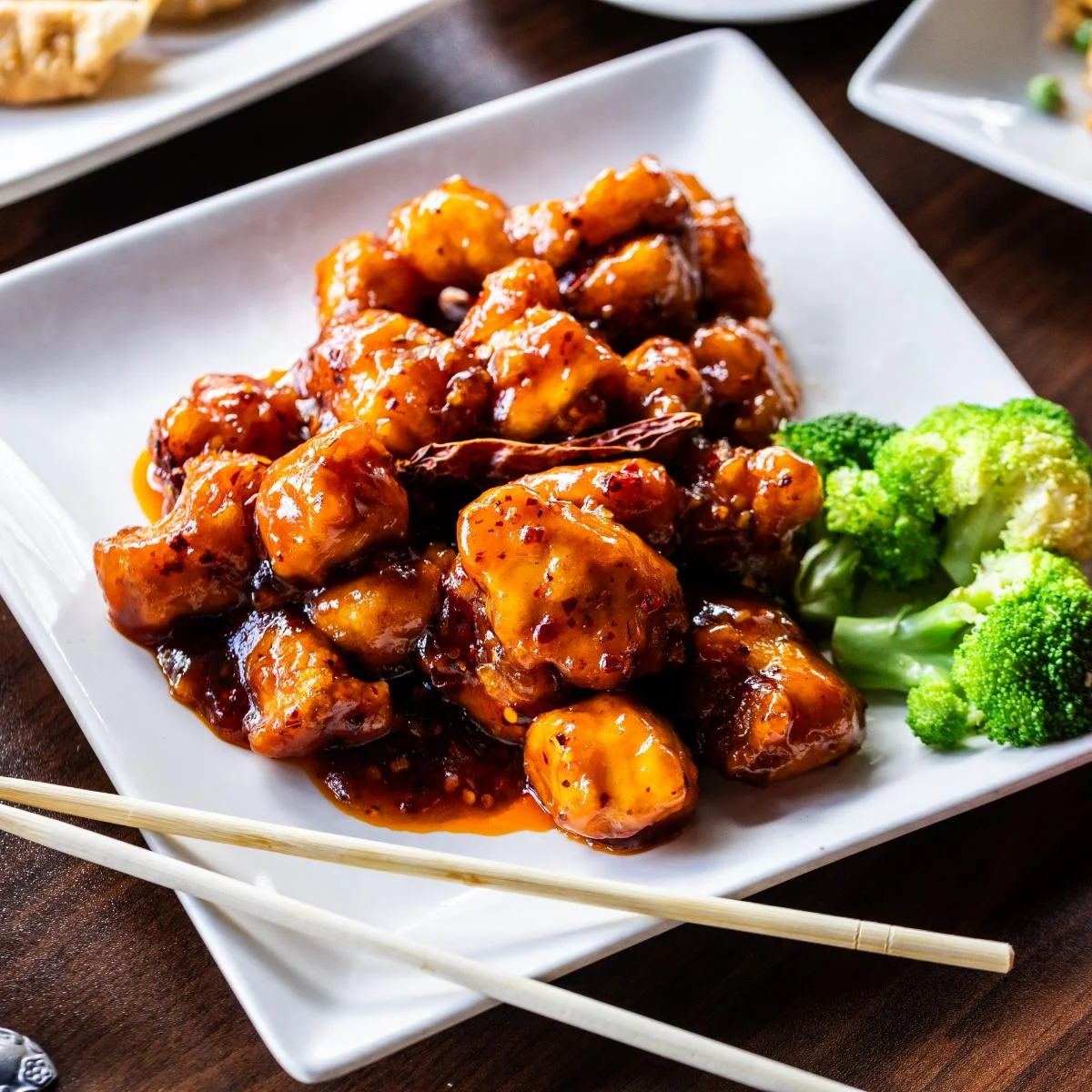Sweet and sour chicken with broccoli on a white plate
