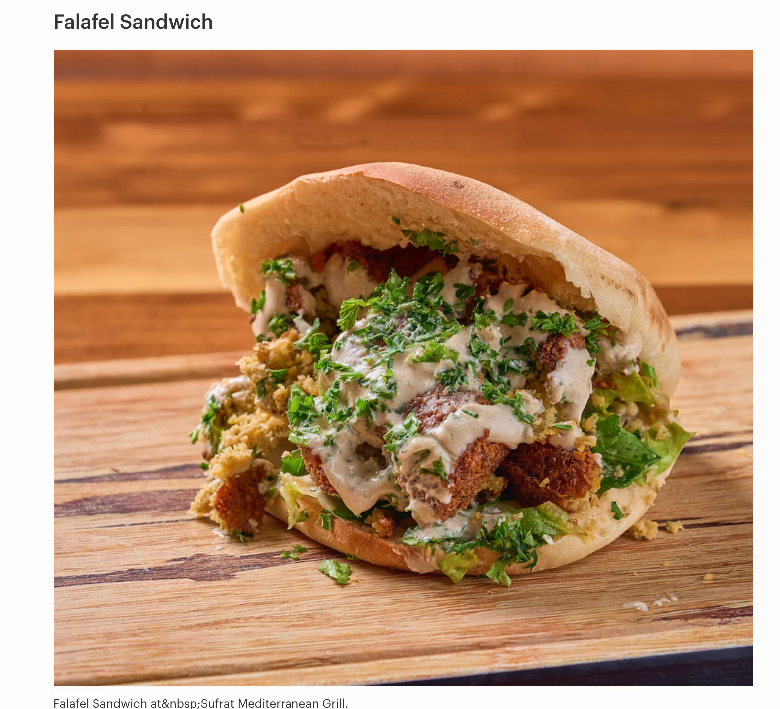 falafel pieces with hummus, lettuce, chopped tomatoes, pickles, and tahini sauce. Served in a freshly-made daily homemade pita.