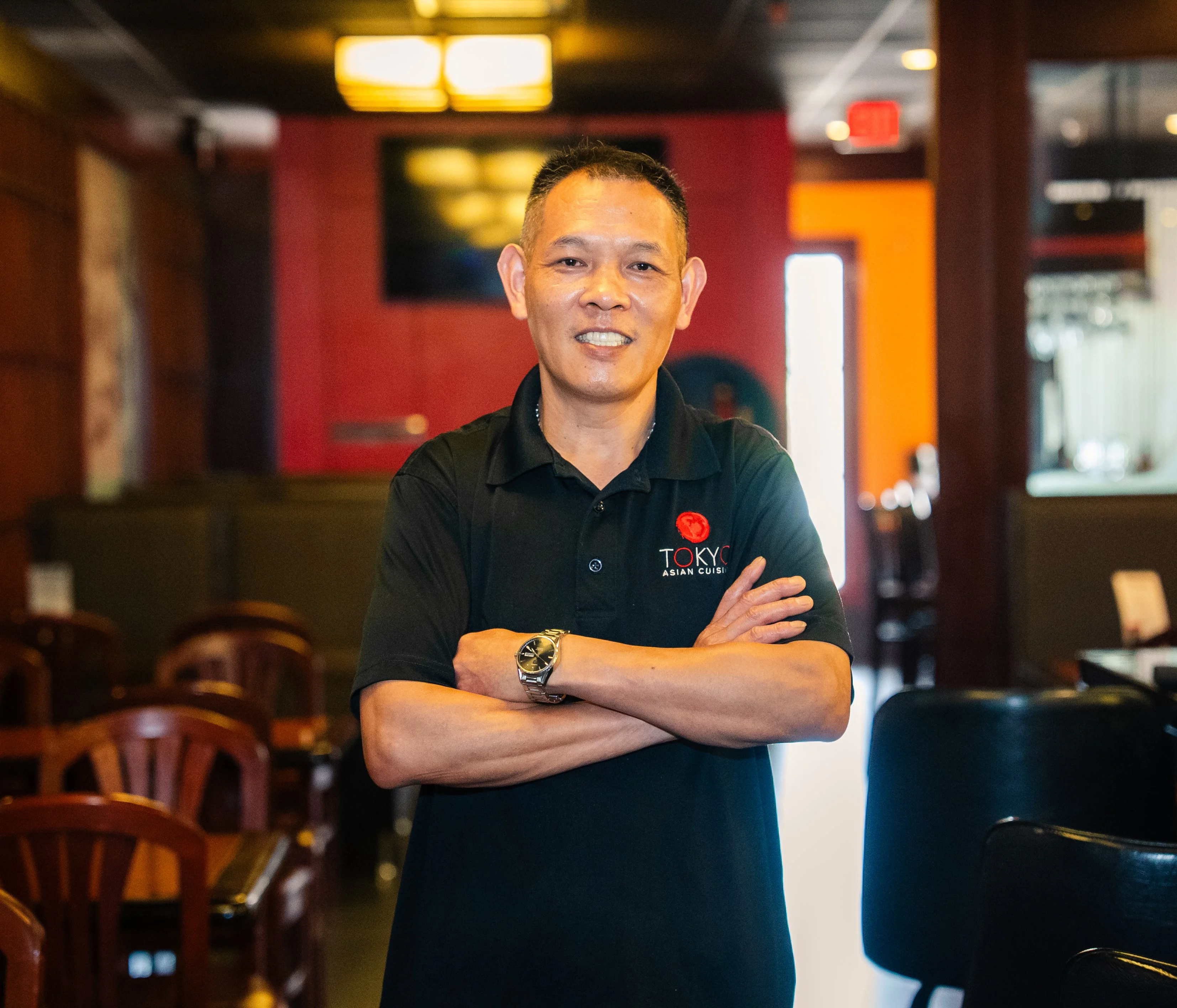Friendly restaurant staff member in a cozy Asian cuisine setting