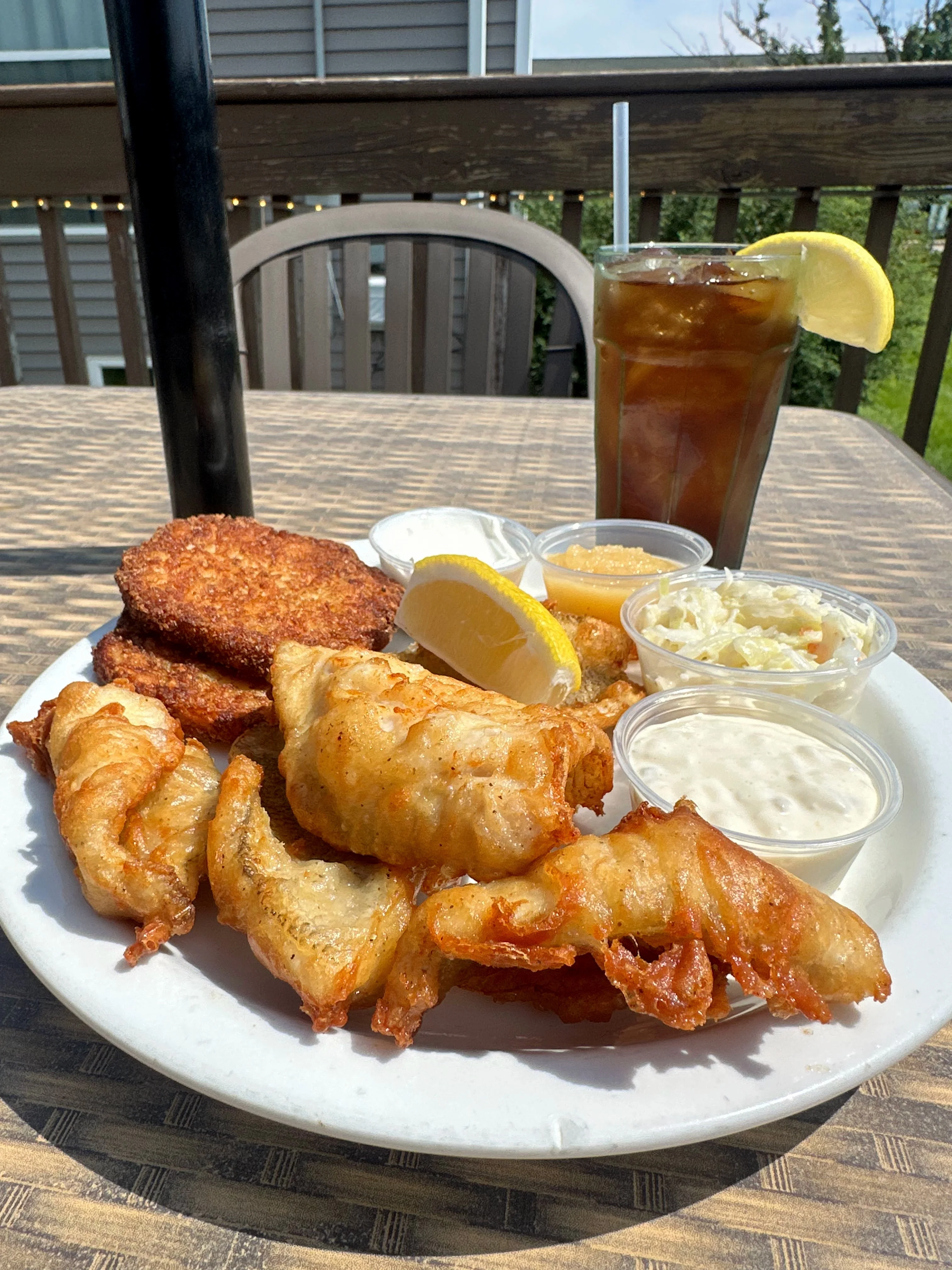Fried fish platter with hushpuppies and sauces, served outdoors