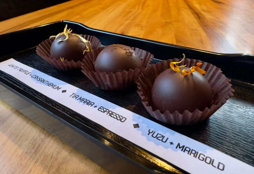 Artisan chocolate truffles on a wooden platter