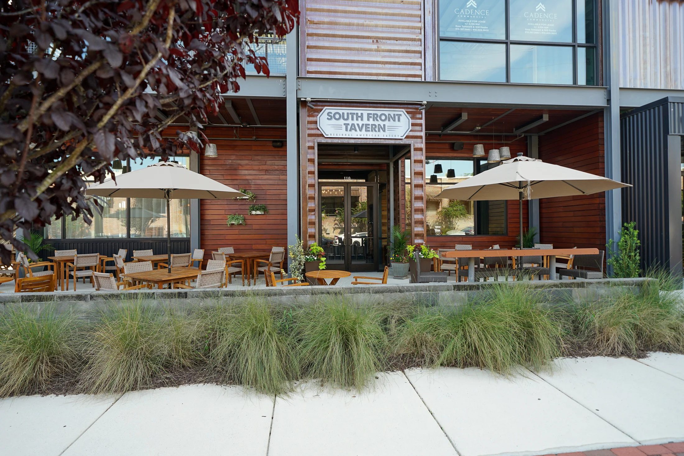 Outdoor dining area of South Front Tavern with umbrellas and wooden furniture