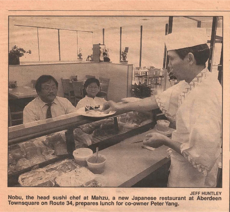 Newspaper clipping of head sushi chef Nobu serving co-owner Peter Yang at the original Mahzu in Aberdeen, NJ