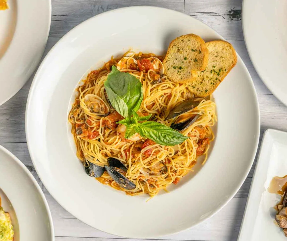 Italian seafood spaghetti with fresh basil and garlic bread