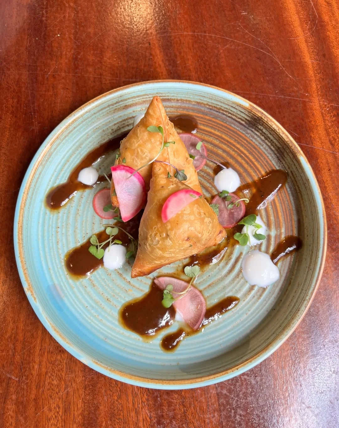Crispy Indian samosas with chutney and garnishes