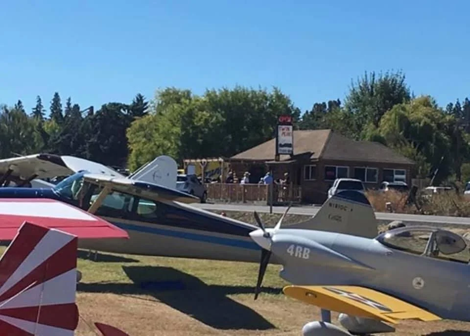 Scenic view of a restaurant near an airstrip with vintage planes