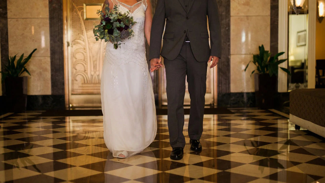 Couple walking hand in hand in elegant wedding attire
