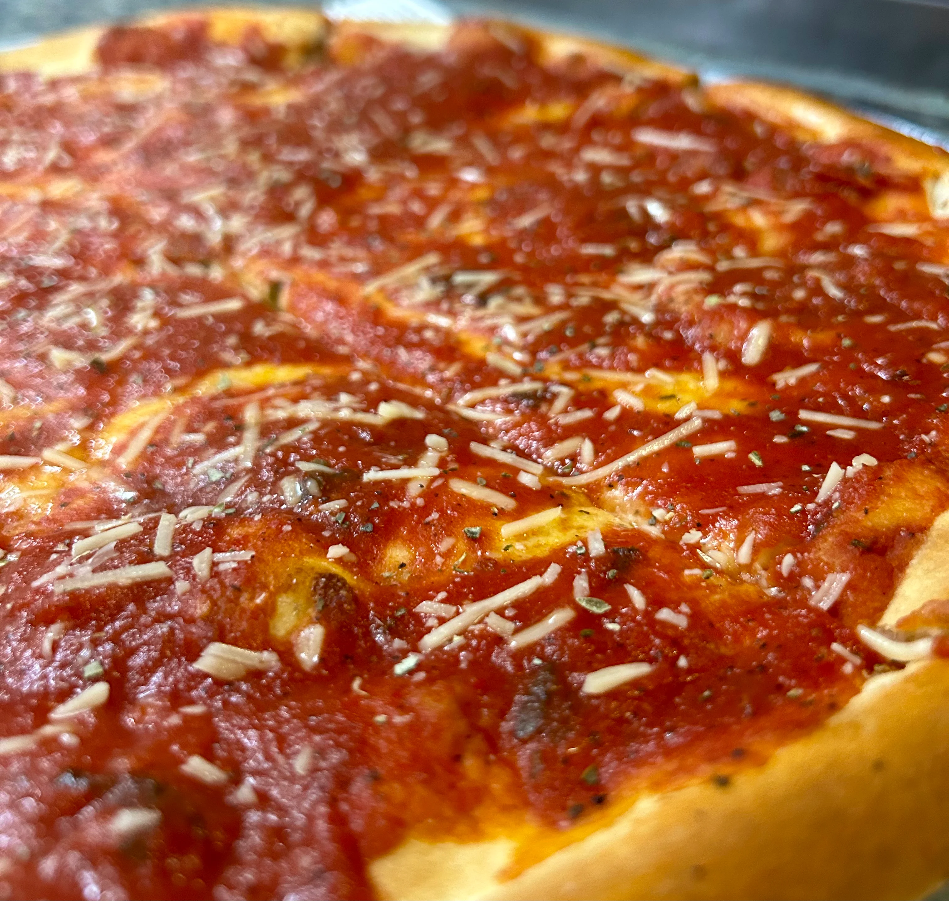 Classic Margherita pizza with tomato sauce, melted mozzarella, and fresh basil on a thin, crisp crust