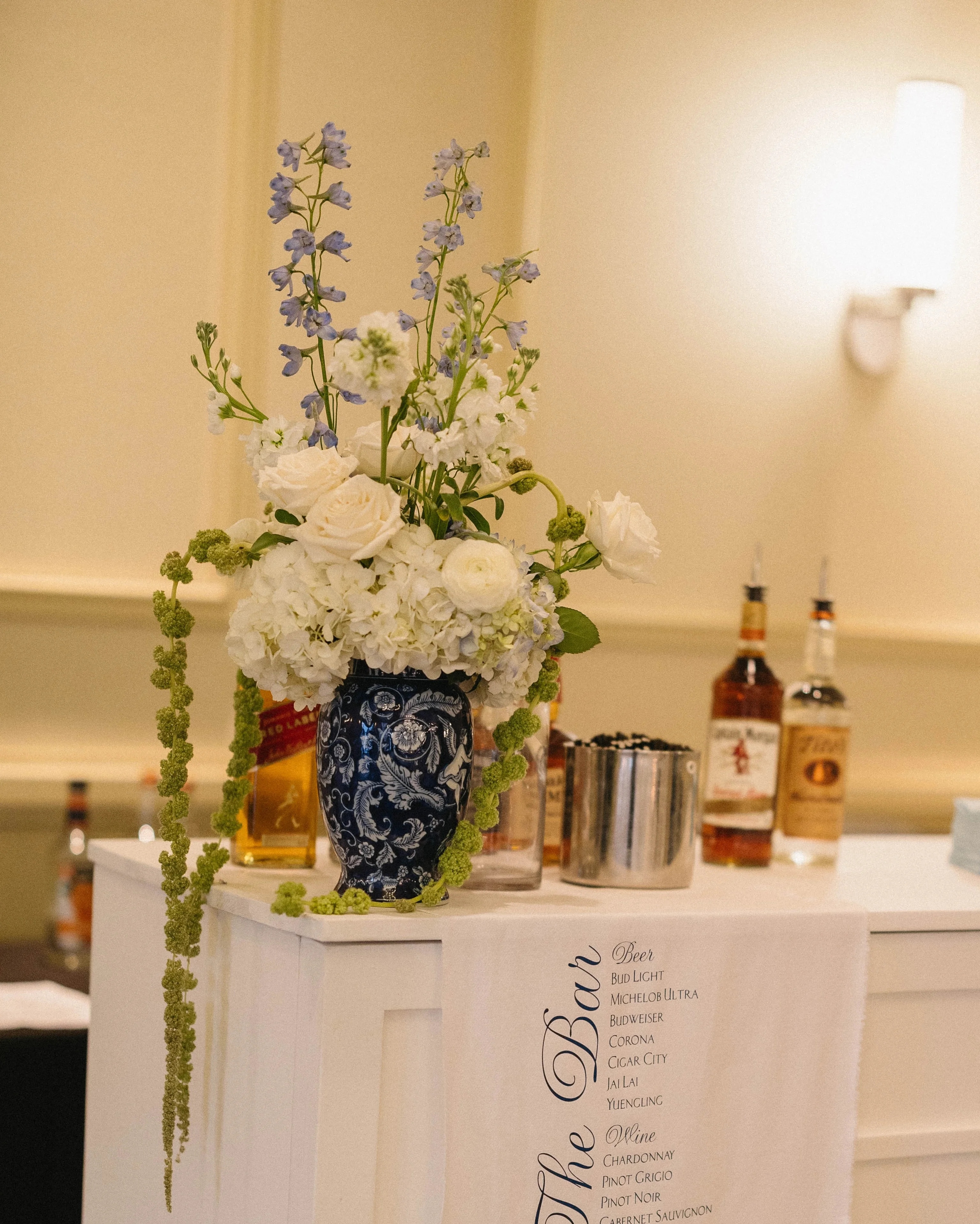 Elegant bar setup with floral arrangement and drink menu