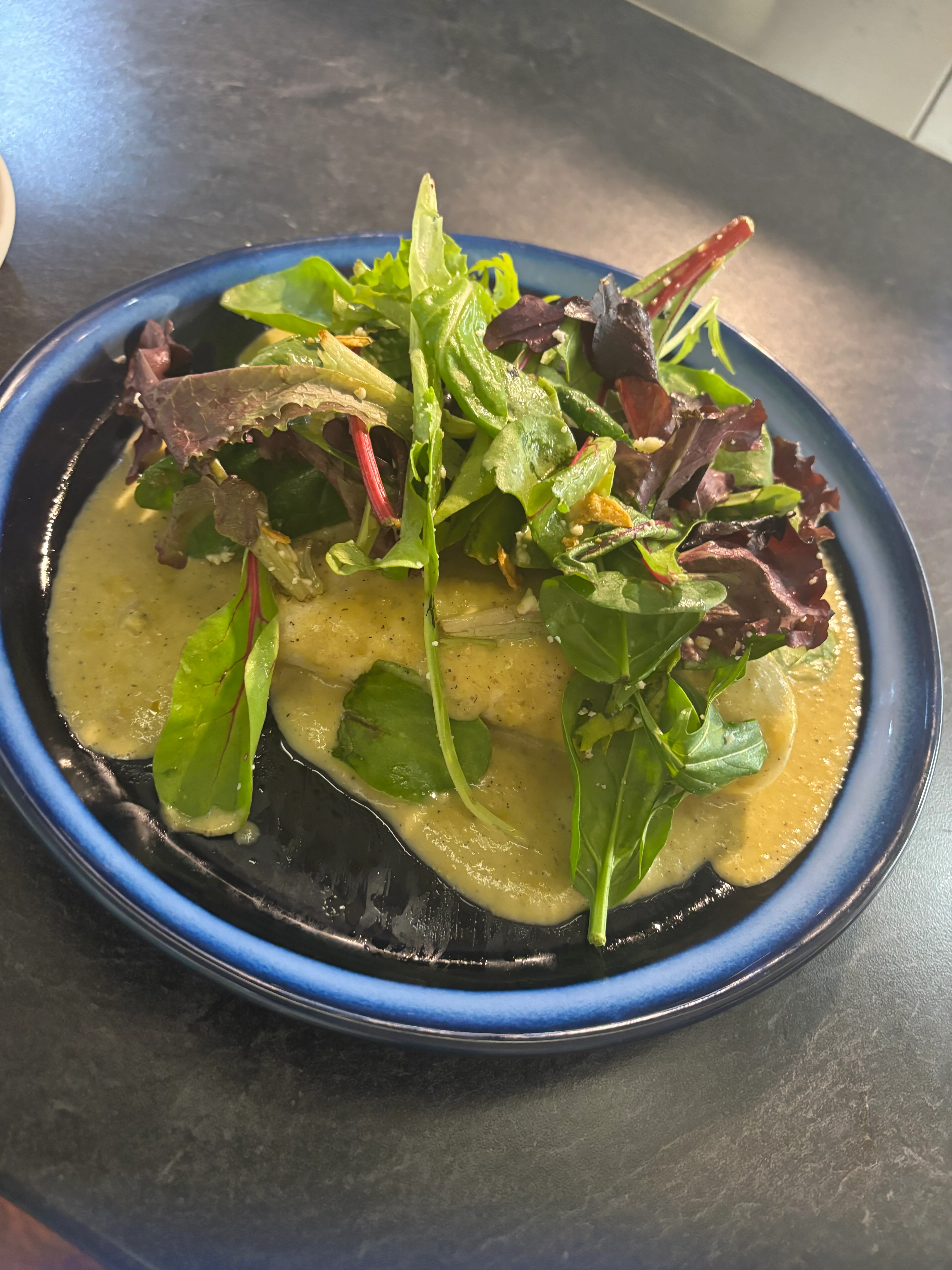 Fresh garden salad with creamy dressing on a blue plate