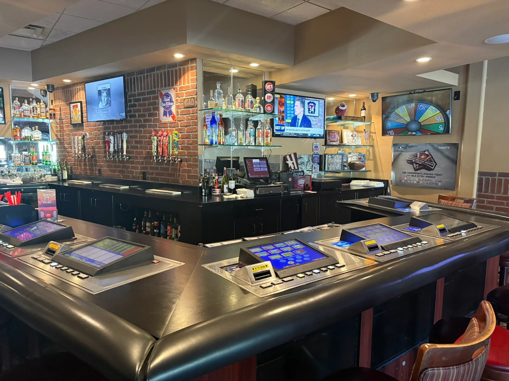 Modern bar interior with gaming stations and exposed brick