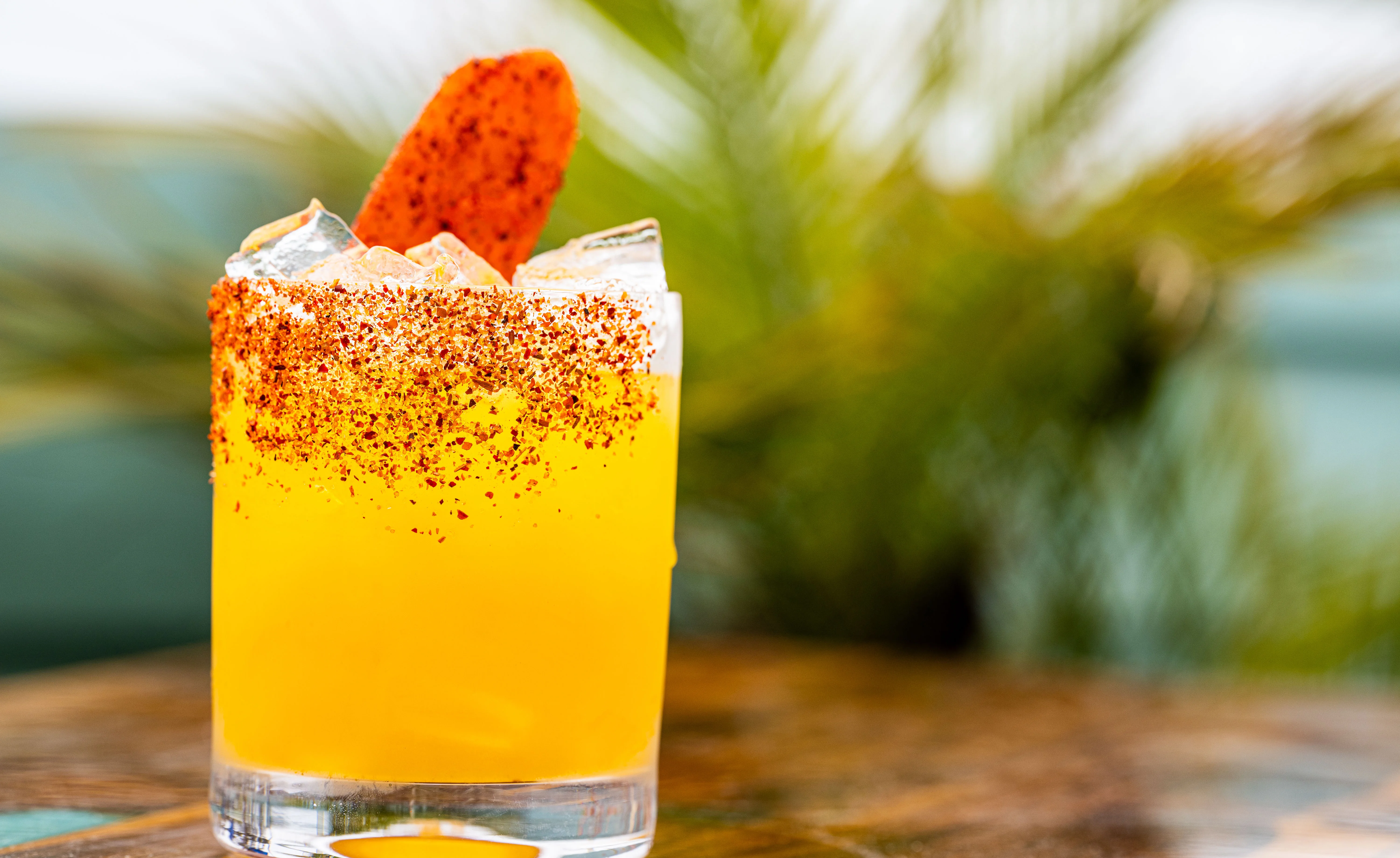 Vibrant Mexican cocktail with chili rim and garnish