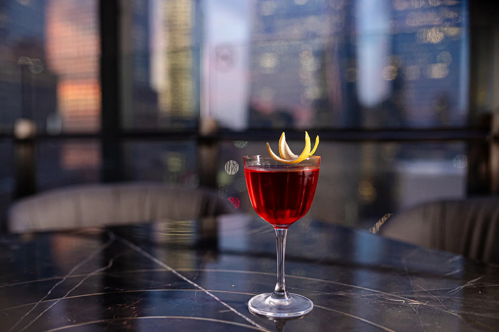 Elegant cocktail with lemon garnish in a modern bar setting