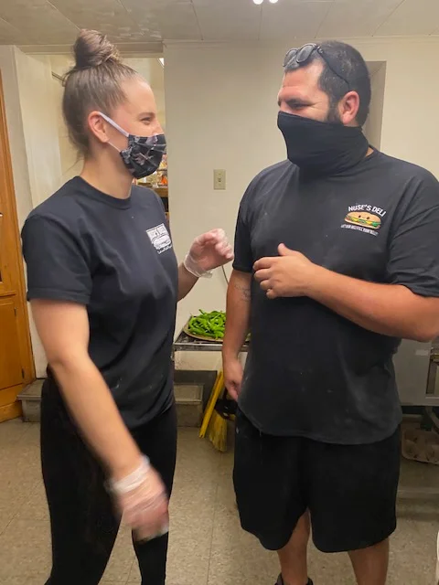 Staff members engaging in friendly conversation in a restaurant kitchen