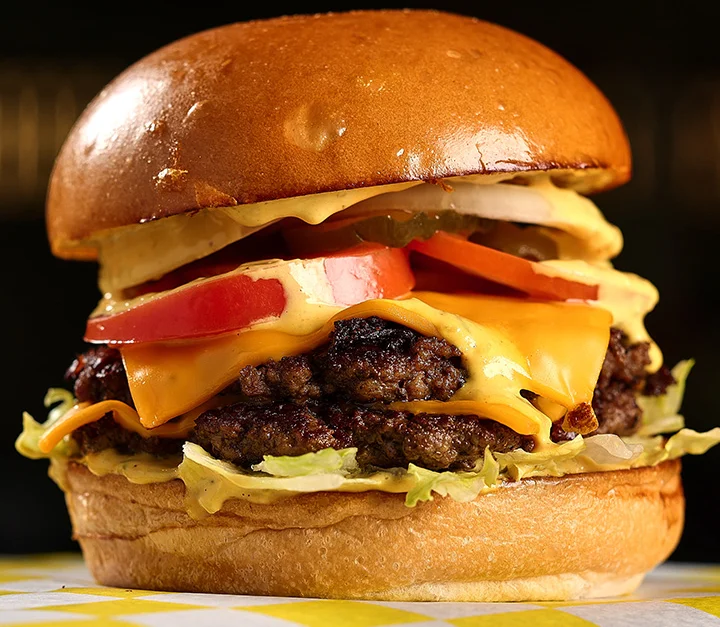 Juicy cheeseburger with lettuce and tomato.