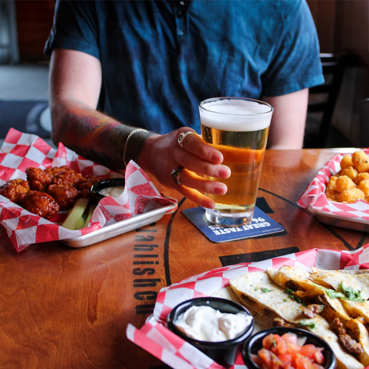 Craft beer with spicy buffalo wings and loaded nachos