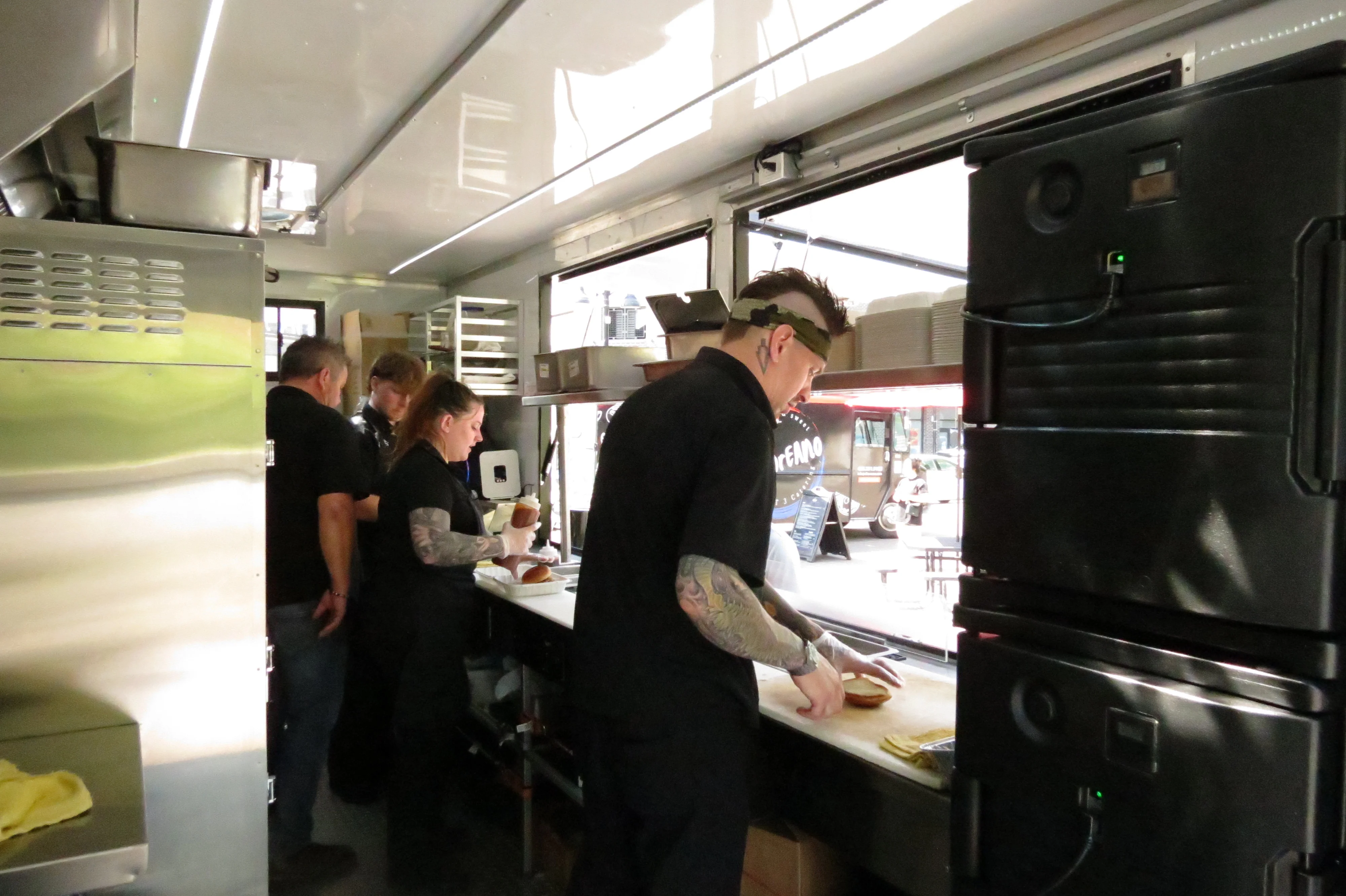 Food truck staff preparing gourmet burgers