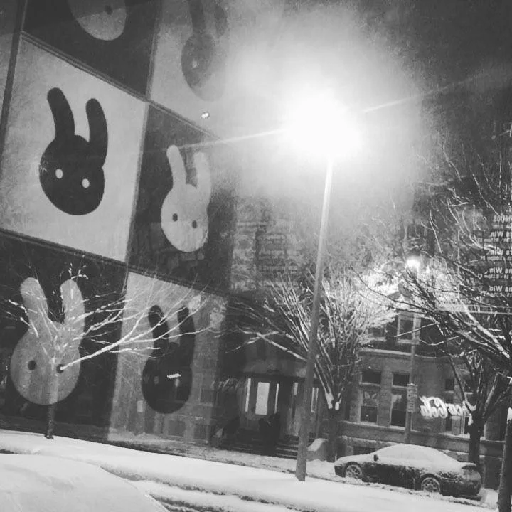 Artistic mural featuring playful bunny designs on a snowy night