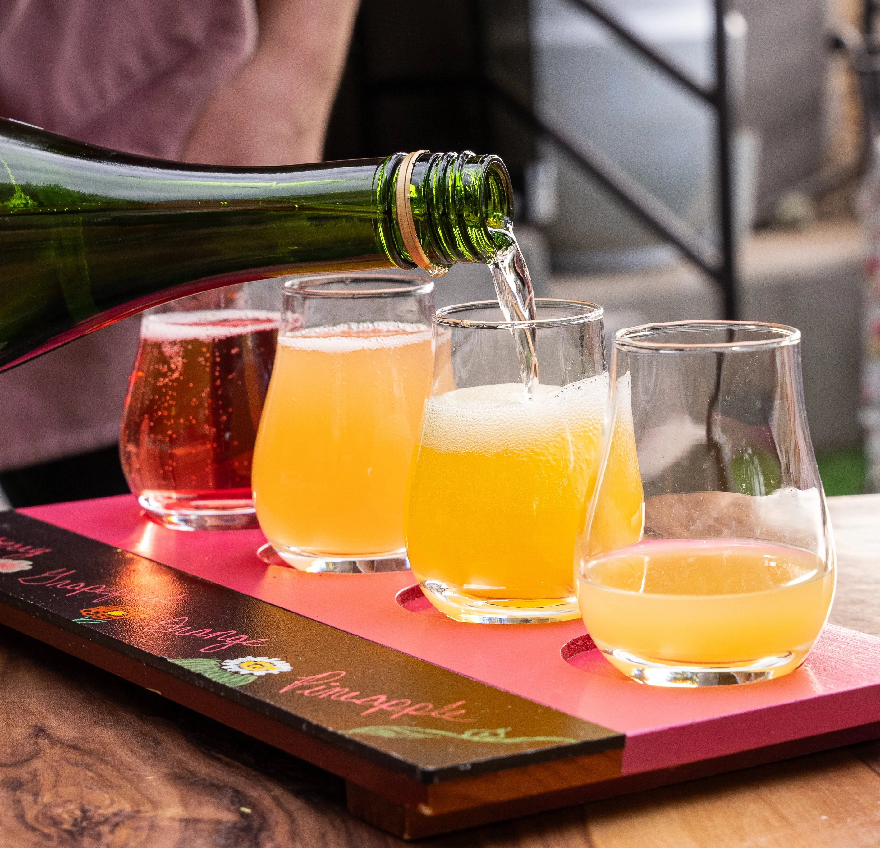 Bartender pouring craft cocktails in a tasting flight