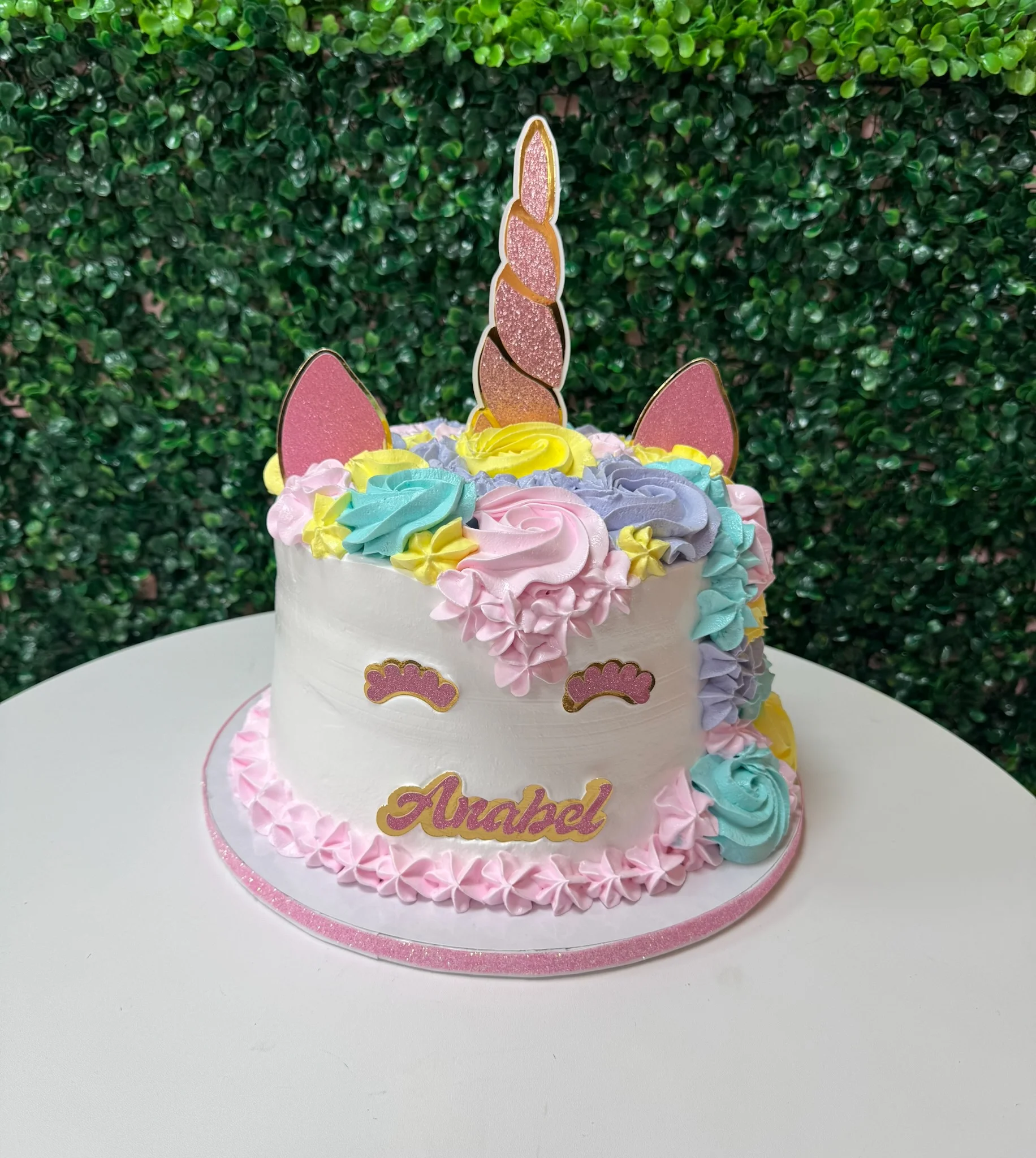 Colorful unicorn cake with decorative frosting and a golden horn