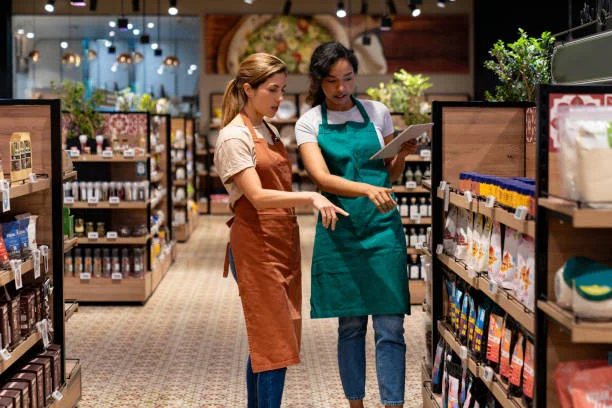 Two women discussing products in a grocery store aisle