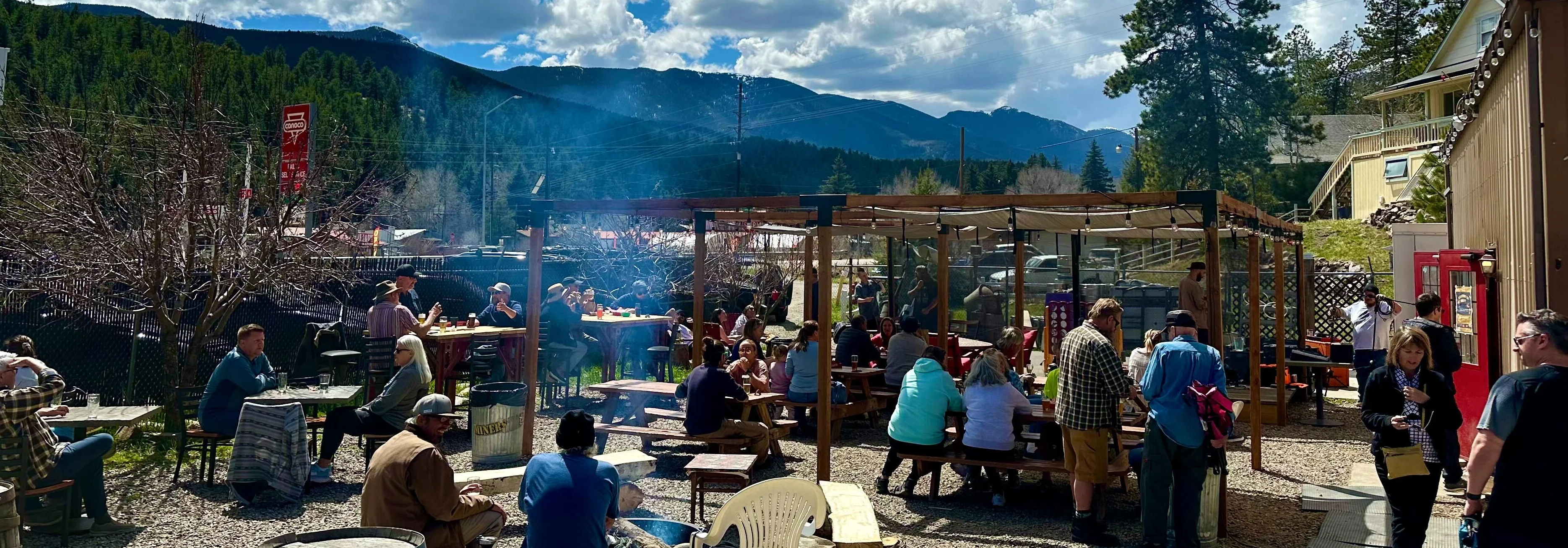 Outdoor dining area with mountain views and patrons enjoying the sun