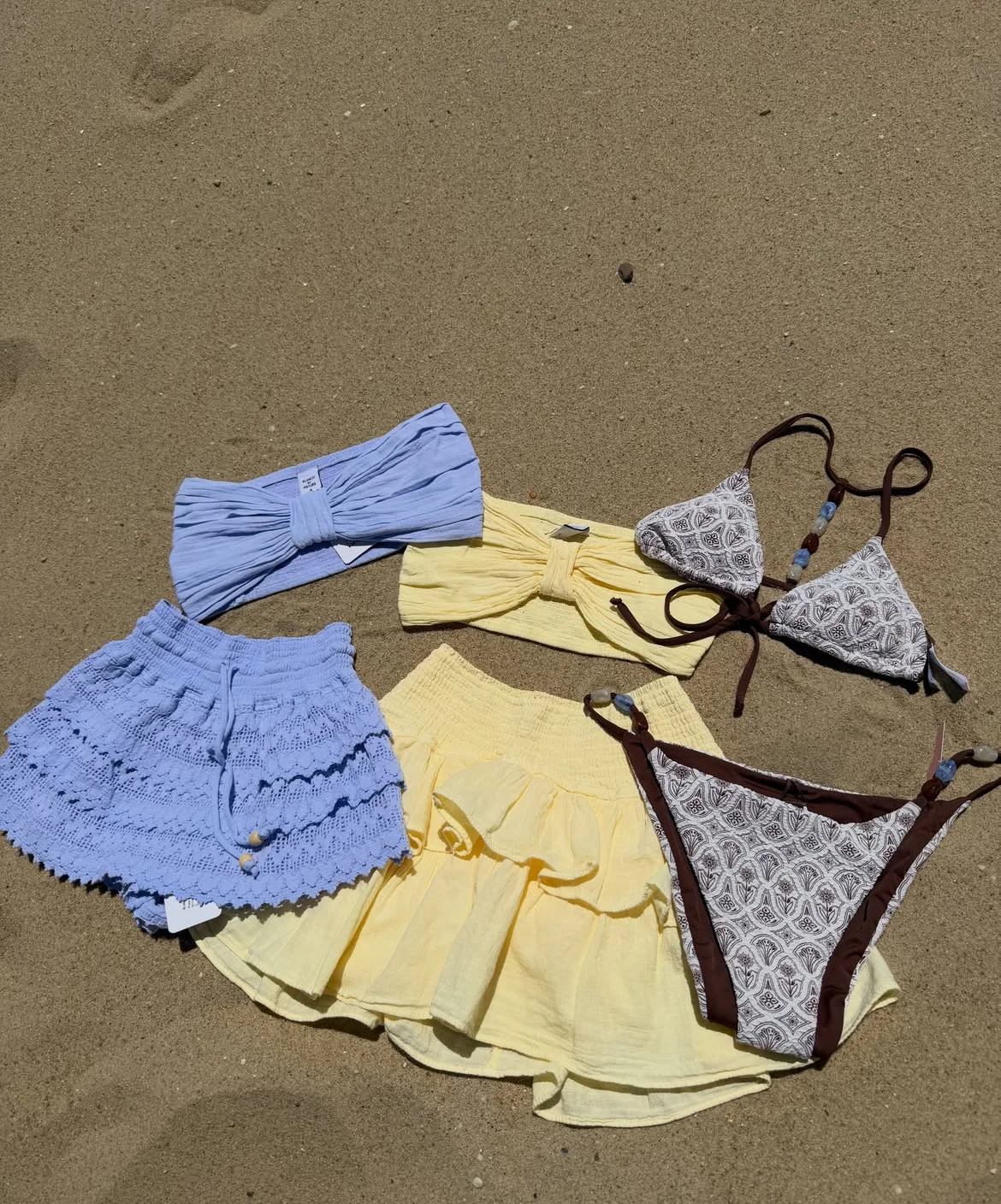 Colorful beachwear collection on sandy beach